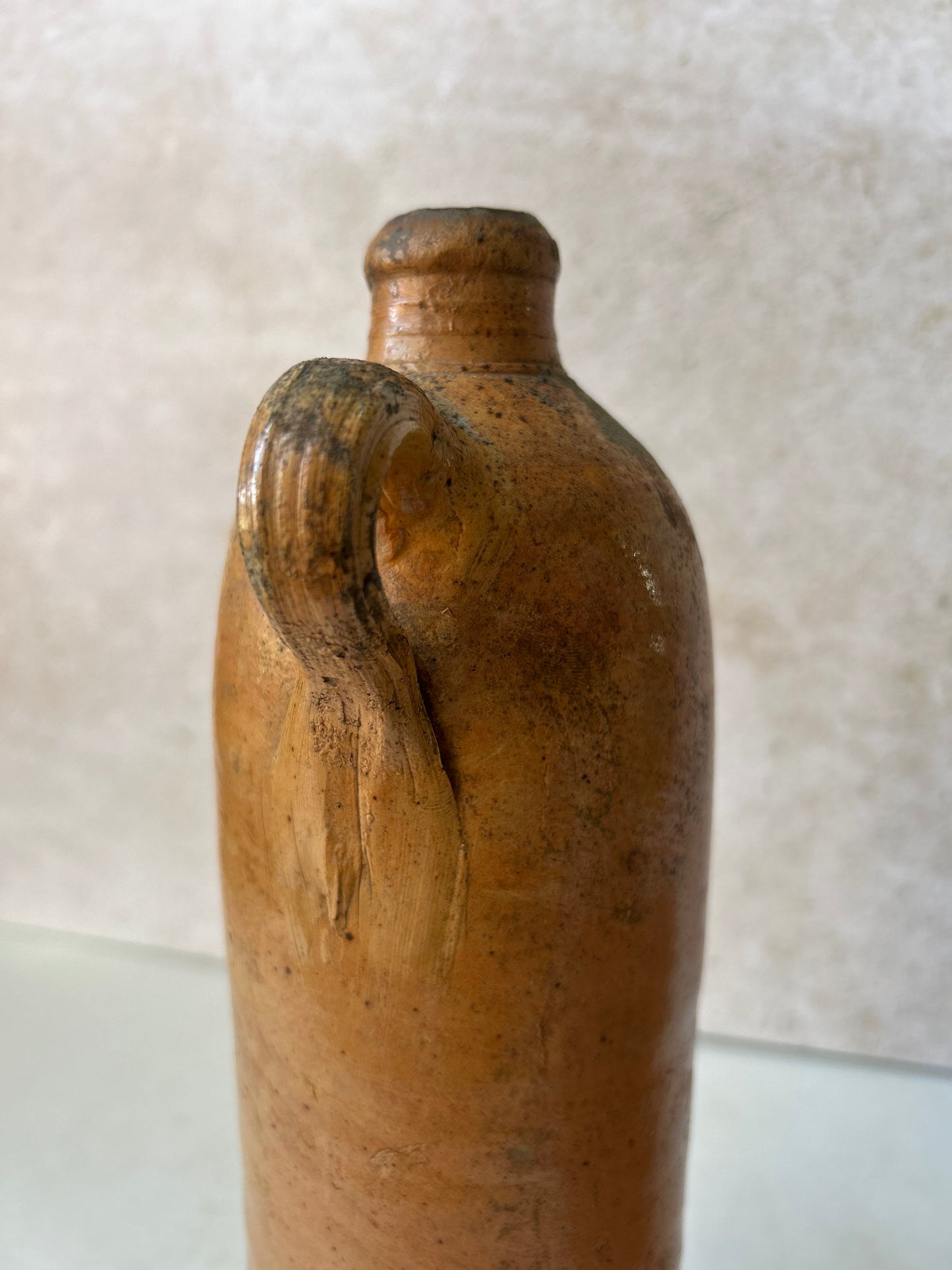 Brown ceramic bottle with a textured surface on a light background